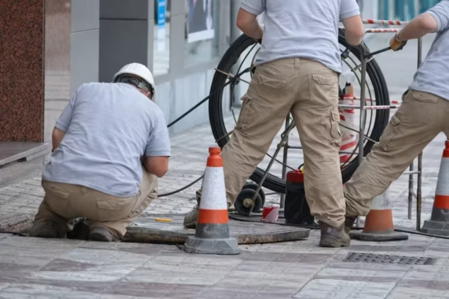 3 technician fixng retail drain